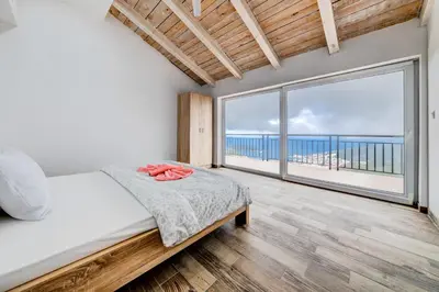 a bedroom with a bed and a large window at Villas Adriatic Horizonte in Budva