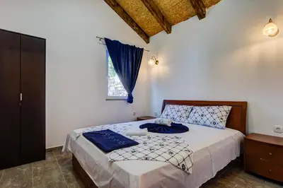 a bedroom with a bed with blue sheets and a window at Villas Adriatic Horizonte in Budva