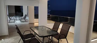 a black dining table and chairs on a balcony at IdealHouse Apartments in Ulcinj