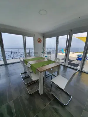 a dining room with a table and chairs and the ocean at Villa Nerin in Zagora
