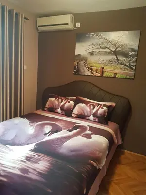 a bedroom with a bed with three swans on it at Apartments Vila Galileo in Budva