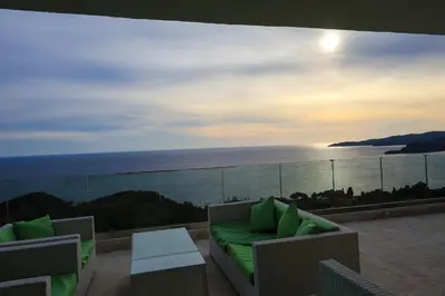 a balcony with a couch and a view of the ocean at Villa Horus in Sveti Stefan