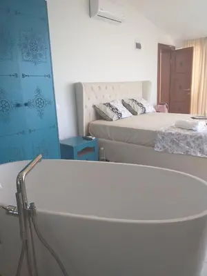 a bath tub in a room with a bed at Villa Horus in Sveti Stefan