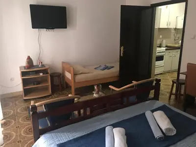 a bedroom with a bed and a living room at Miron apart&rooms in Rafailovici