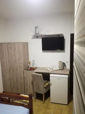 a kitchen with a table and a chair in a room at Miron apart&rooms in Rafailovici