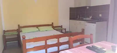 a small bedroom with a bed and a kitchen at Miron apart&rooms in Rafailovici
