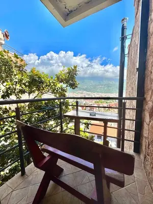 a bench sitting on a balcony with a table at Contessa Apartments in Budva