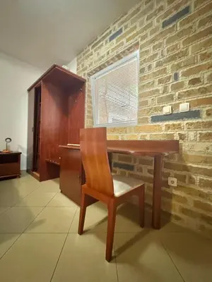a wooden desk with a chair and a brick wall at Contessa Apartments in Budva