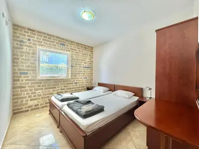 a bedroom with a bed and a brick wall at Contessa Apartments in Budva