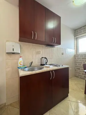 a kitchen with a sink and wooden cabinets at Contessa Apartments in Budva