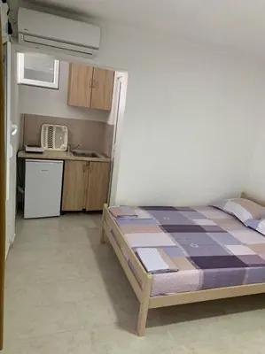 a bedroom with a bed and a small kitchen at Apartments Beho in Ulcinj