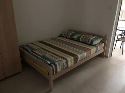 a small bed in a room with a table at Apartments Beho in Ulcinj