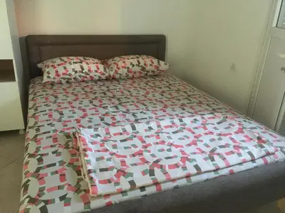 a bed with a quilt and two pillows on it at Apartments Beho in Ulcinj