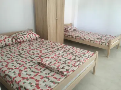 a bedroom with two beds and a bed with a quilt at Apartments Beho in Ulcinj