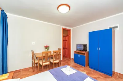 a room with a dining table and a blue cabinet at Villa Glavanovic in Bar
