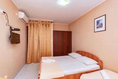 a small bedroom with a bed and a window at Villa Glavanovic in Bar