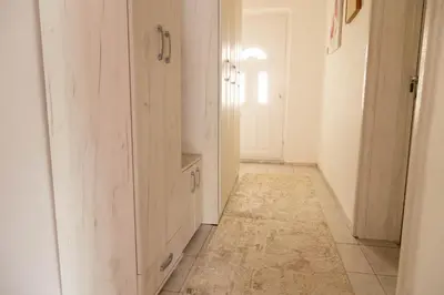 a hallway with white cabinets and a tile floor at Apartmani Marojević, Bar in Bar
