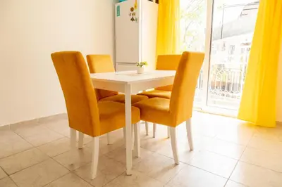 a dining room table with orange chairs and a window at Apartmani Marojević, Bar in Bar