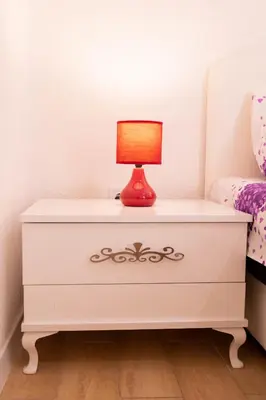 a white dresser with a lamp on it in a bedroom at Apartmani Marojević, Bar in Bar