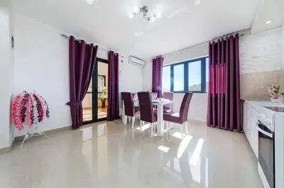 a dining room with purple curtains and a table and chairs at Alt Braic Villa in Budva