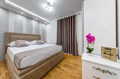 a bedroom with a large bed and a vase of flowers at Alt Braic Villa in Budva