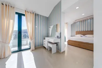 a bedroom with a bed and a large window at Alt Braic Villa in Budva