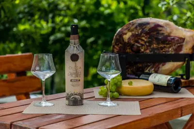 a bottle of wine sitting on a table with two glasses at Alt Braic Villa in Budva