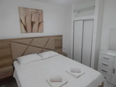 a bedroom with a white bed with two towels on it at Apartment Iv in Kotor