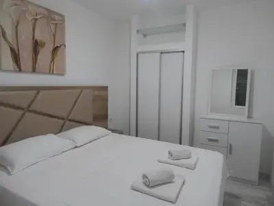 a bedroom with a white bed with two towels on it at Apartment Iv in Kotor