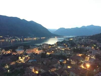 a view of a city and a river at night at Apartment Iv in Kotor