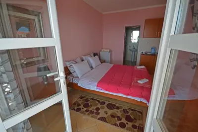 a small bedroom with a bed with a red blanket at Apartments Cejovic in Ulcinj