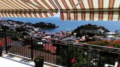 a view of a city from a balcony with an umbrella at Apartments Cejovic in Ulcinj