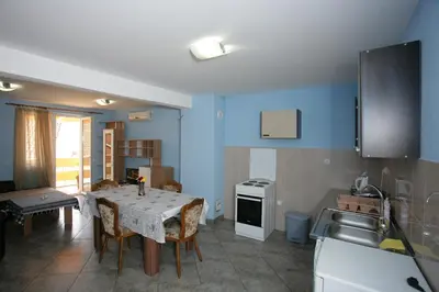 a kitchen with a table and chairs in a kitchen at Apartments Cejovic in Ulcinj