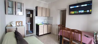 a small kitchen with a dining table and a tv on the wall at Apartments Cejovic in Ulcinj