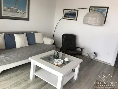 a living room with a couch and a coffee table at Loft Infinity in Petrovac na Moru