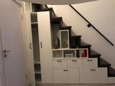 a stairway with a book shelf under a staircase at Loft Infinity in Petrovac na Moru