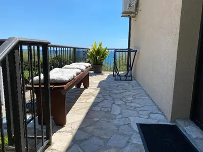 a bench with pillows sitting on a balcony at Loft Infinity in Petrovac na Moru