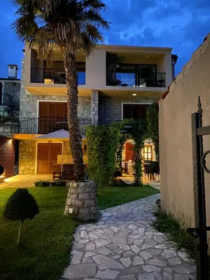 a palm tree in front of a house at Loft Infinity in Petrovac na Moru