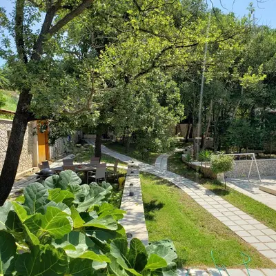 a garden with plants and trees and a sidewalk at Green Hill Apartments in Ulcinj