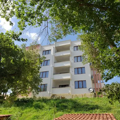 a white building with trees in front of it at Green Hill Apartments in Ulcinj