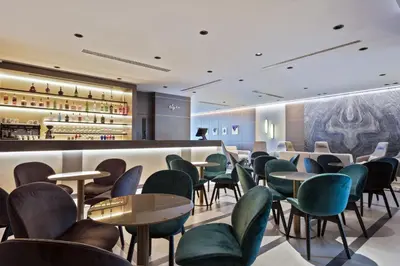 a waiting room with green chairs and tables at Hotel AMI Budva Petrovac in Petrovac na Moru