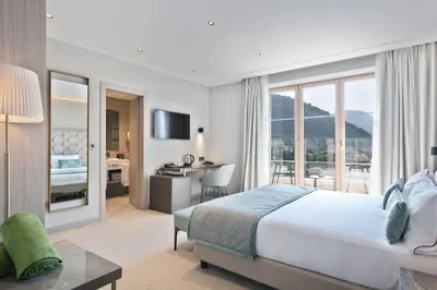 a hotel room with a bed and a desk with a view at Hotel AMI Budva Petrovac in Petrovac na Moru