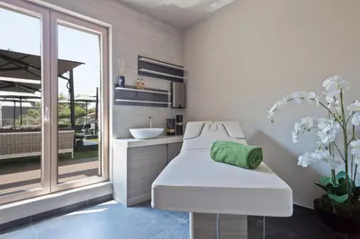 a bathroom with a white chair and a sink at Hotel AMI Budva Petrovac in Petrovac na Moru
