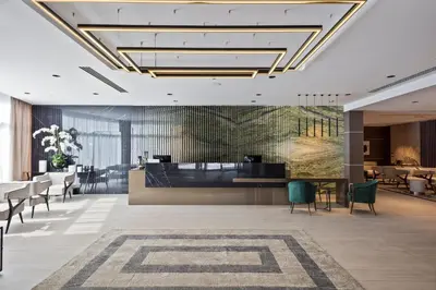 a lobby of a hotel with a table and chairs at Hotel AMI Budva Petrovac in Petrovac na Moru