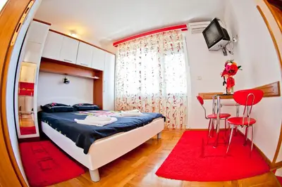 a bedroom with a bed and a table with a red rug at Apartments Stefan in Becici