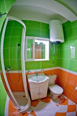 a green and orange bathroom with a sink and a toilet at Apartments Stefan in Becici