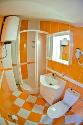 an orange and white bathroom with a toilet and sink at Apartments Stefan in Becici