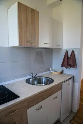 a kitchen with a sink and white cabinets at La Dolce Vita Residence in Ulcinj