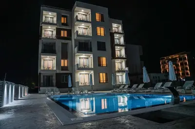 a hotel with a swimming pool in front of a building at La Dolce Vita Residence in Ulcinj