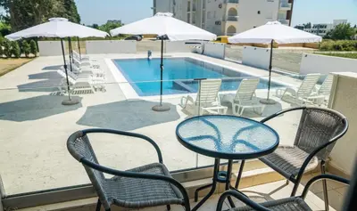 a patio with a table and chairs and a swimming pool at La Dolce Vita Residence in Ulcinj